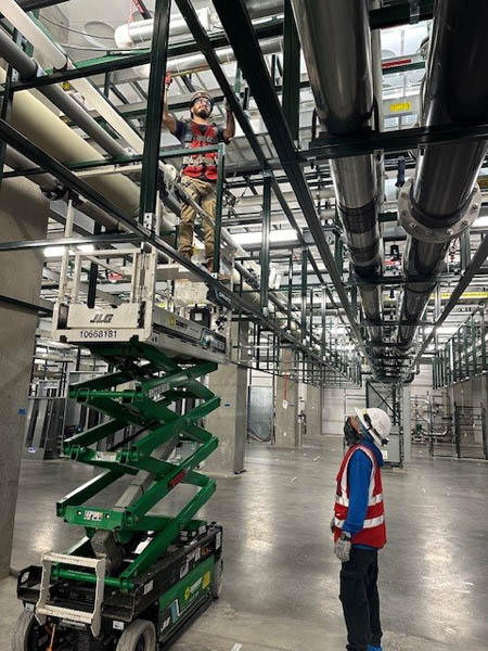 Worker using lift in factory